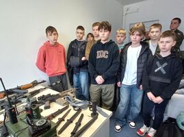 Grupa chłopców poznaje jak wygląda broń palna oraz inne potrzebne rzeczy w wojsku.jpg