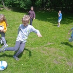 Grupa chłopców gra w piłkę nożną.