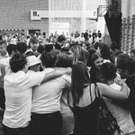 Uczniowie klas ósmych przytulają się do siebie na pożegnanie.