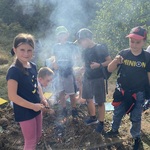 Grupa dzieci stoi wokół rozpalonego samodzielnie ogniska.jpg
