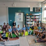 Uczniowie klasy 1a siedzą na pufach w bibliotece. Słuchają głośnego czytania..jpg