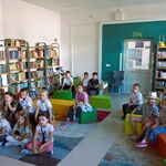 W bibliotece uczniowie klasy 1c siedzą na pufach. Słuchają głośnego czytania książki..jpg