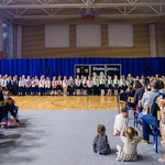 Uczniowie klas pierwszych stoją na sali gimnastycznej podczas uroczystości ślubowania.