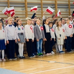 Uczniowie z klas trzecich śpiewają i trzymają flagi Polski..jpg