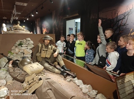 Grupa dzieci ogląda polskich żołnierzy na wystawie muzealnej..jpg