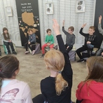 Dzieci siedzą w kręgu i podnoszą rękę_ odpowiadając na zdane pytania przewodnika..jpg