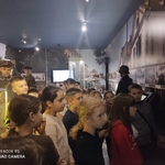 Grupa dzieci ogląda stare fotografie zawieszone na ścianach..jpg