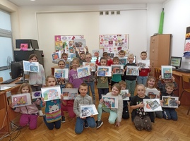Dzieci prezentują wykonane i wydrukowane kolorowanki przedstawiające rózne postacie z bajek.jpg