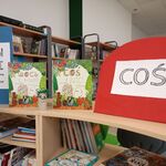 1 W bibliotece szkolnej półka z książkami. Wyeksponowane są dwie książki i kartoniki z napisem COŚ i NIC..jpg