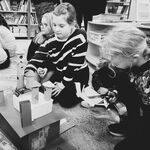 8 Uczniowie siedzą na dywanie i tworzą budowle z kartoników_ rolek po papierze..jpg