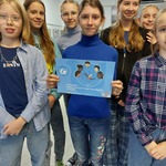 Grupa ubranych na niebiesko uczniów prezentuje plakat dotyczący Dnia Praw Dziecka.jpg