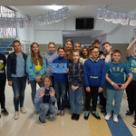 Grupa uczniów ubrana na niebiesko pozuje do zdjęcia_ w tle duży napis Dzień Praw Dziecka.jpg