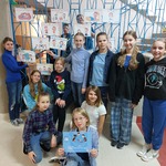Grupa uczniów ubranych na niebiesko prezentuje plakaty dotyczące praw dzieci.jpg