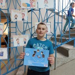 Ubrany na niebiesko chłopiec trzyma kartkę z logo Unicef_ w tle gazetka dotycząca praw dziecka.jpg