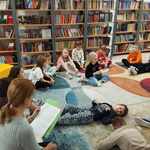 Nauczycielka czyta bajkę terapeutyczną uczniom siedzącym i wypoczywającym na podłodze .jpg