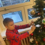 Chłopiec dekoruje choinkę bombką. (2).jpeg