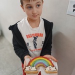 chłopiec prezentuje ciasto w kształcie tęczy.jpg