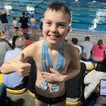 Chłopiec po wygranej w zawodach pływackich pozuje do zdjęcia.jpg