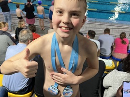 Chłopiec po wygranej w zawodach pływackich pozuje do zdjęcia.jpg