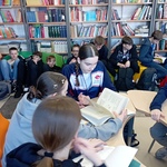 Uczniowie w biobliotece pracują w grupach_ przeglądając książki.jpg