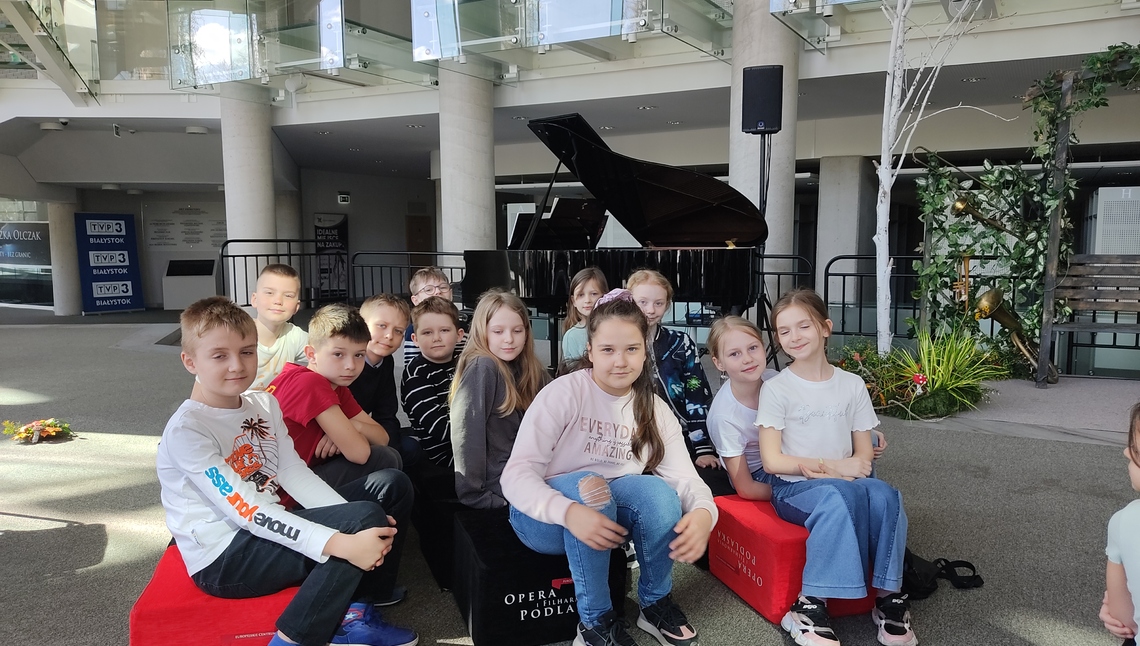 Grupa dzieci pozuje do zdjęcia na tle fortepianu..jpg