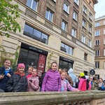 Grupa uczniów stoi przed budynkiem mieszczącym Manufakturę Czekolady w Warszawie.jpg