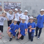 Dziewczynki i chłopcy w kolorowych koszulkach i srebrnych kapeluszach pozują do zdjęcia po występie teatralnym..jpg