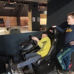 Dwóch chłopców próbuje swoich sił w symulatorze jazdy samochodem..jpg