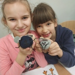 dwie dziewczynki pokazuja myszki ze skarpetek wykonane na zajęciach.jpg